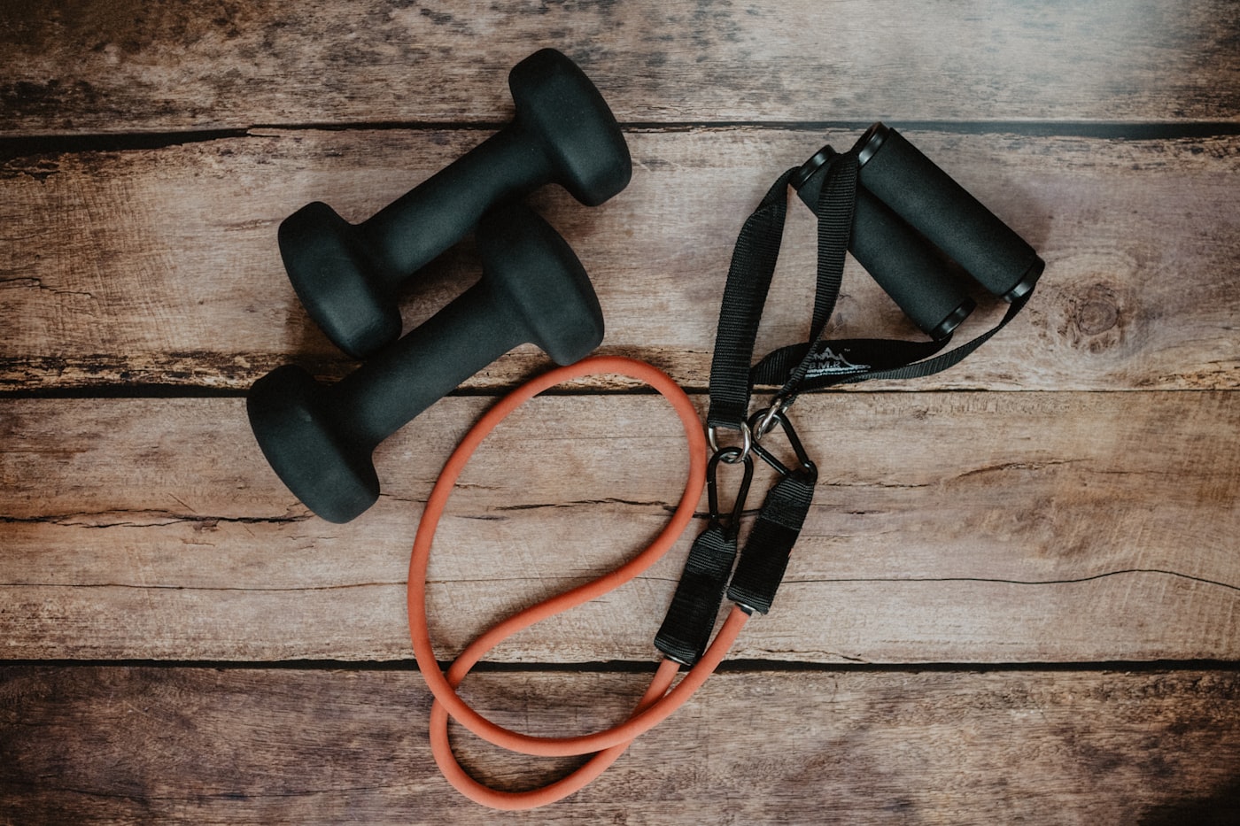 Dumbbells and a resistance band on a timber floor